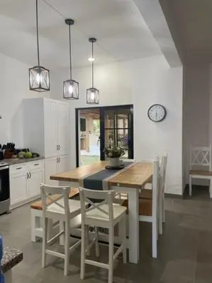 a kitchen with a table and chairs and a clock at Villas Elim A and B in Cabrera