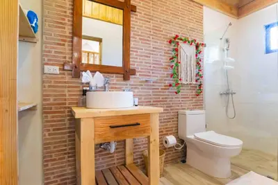 a bathroom with a white sink and a brick wall at Hacienda La Huerta, Puerto Plata in San Felipe de Puerto Plata