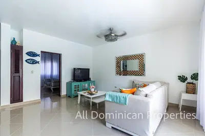 a living room with a couch and a table at Paradise Condos, Cabarete! in Cabarete