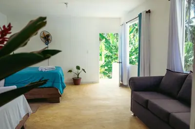 a living room with a couch and a bed at Parador El Ermitaño in Santa Bárbara de Samaná