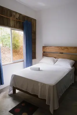 a bedroom with a large white bed with a window at Parador El Ermitaño in Santa Bárbara de Samaná