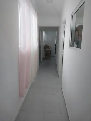 a hallway with a white floor and a picture on a wall at Tropical Optimal Tropicana Sur in Sosúa