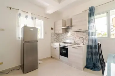 a kitchen with a stainless steel refrigerator and cabinets at Villa Vintage. in Boca Chica