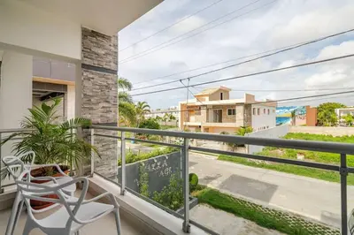 a balcony with a chair and a view of a street at Villa Vintage. in Boca Chica