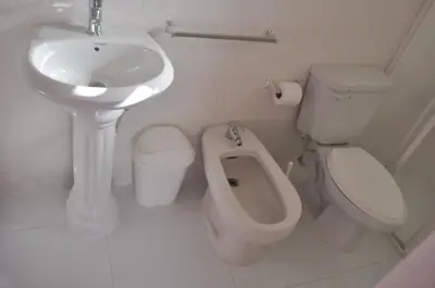 a white bathroom with a sink and a toilet at Residencial Lucy in Boca Chica