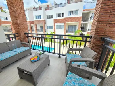a balcony with chairs and a table and a building at Beauty Apartment Coral Village 2 close to the beach in Punta Cana