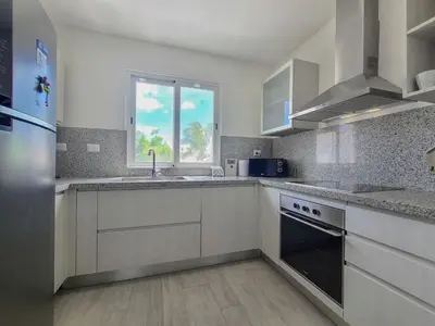 a large kitchen with white cabinets and a window at Beauty Apartment Coral Village 2 close to the beach in Punta Cana