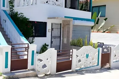 a white fence in front of a building at Apartamento entero en Samaná Los tios 1 y 2 in Santa Bárbara de Samaná