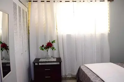 a bedroom with a bed and a vase of flowers on a table at Apartamento entero en Samaná Los tios 1 y 2 in Santa Bárbara de Samaná