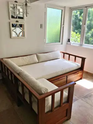 a wooden couch in a room with two windows at Amazing apartment, B-Juan Dolio, El Bonio II in Juan Dolio