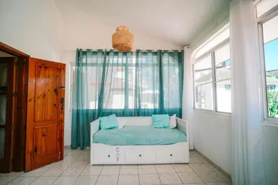 a bedroom with a bed with blue sheets and a window at Sueño Caribeño in La Laguna