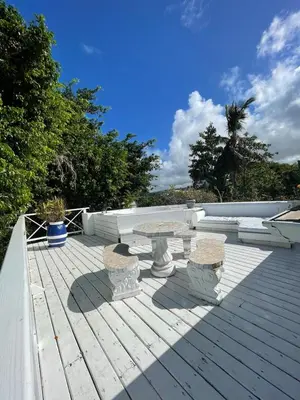 a table and two benches on a wooden deck at ITAKA LOMA BONITA in Las Terrenas