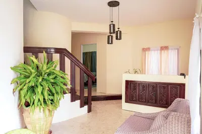 a living room with a staircase and a potted plant at Refugio Encantador in Santo Domingo