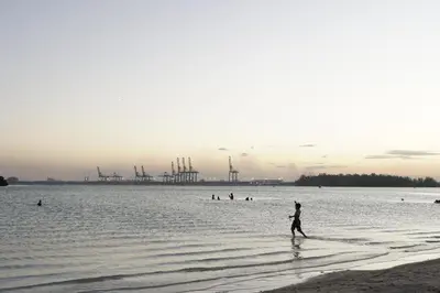 a person walking on the beach in the water at Villa Gumio Studio Apt - 7 minutes walk to Boca Chica Beach apts in Boca Chica
