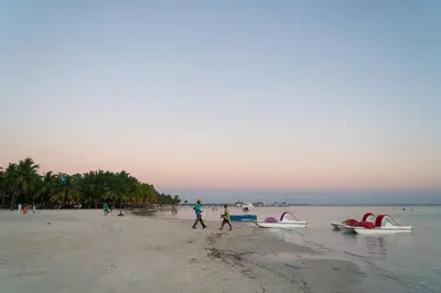 a group of people walking on a beach with boats at Villa Gumio Studio Apt - 7 minutes walk to Boca Chica Beach apts in Boca Chica