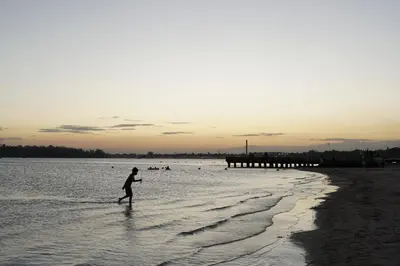 a person walking in the water on the beach at Villa Gumio 2BR Apt- 7 min walk to Boca Chica Beach apts in Boca Chica