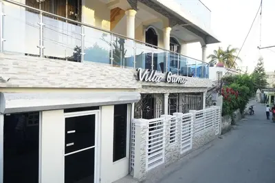 a white building with a window store on a street at Villa Gumio 2BR Apt -7min walk Boca Chica Beach apts in Boca Chica