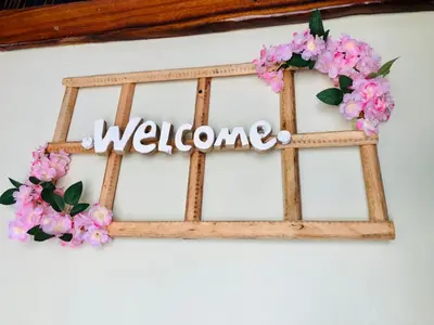 a welcome sign on a wall with pink flowers at Baby Rustic in Punta Rucia