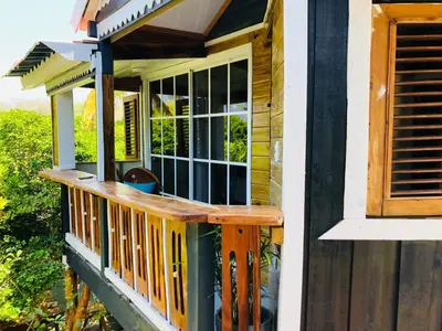 a porch with a wooden railing on a house at Baby Rustic in Punta Rucia