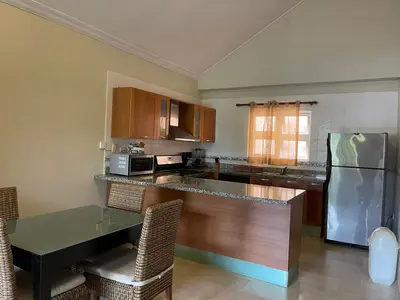 a kitchen with a table and a refrigerator at Laguna Golf in Punta Cana