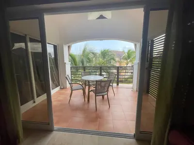 a patio with a table and chairs on a balcony at Laguna Golf in Punta Cana