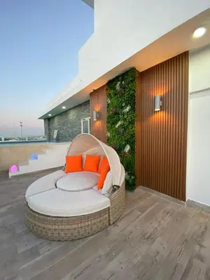 a wicker bed sitting on a patio with a wall at Central Suites Tower in Santo Domingo