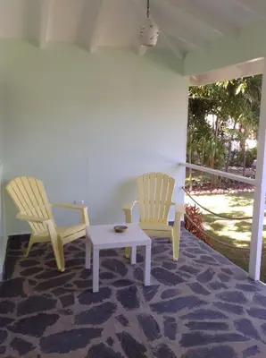 two chairs and a coffee table on a porch at Bungalow Natura Village in Sosúa
