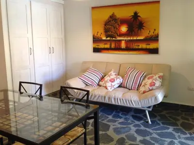 a living room with a couch and a table at Bungalow Natura Village in Sosúa