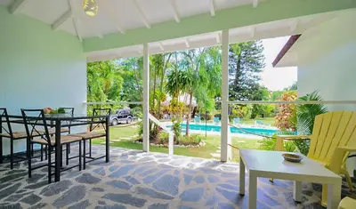 a large living room with a table and chairs at Bungalow Natura Village in Sosúa