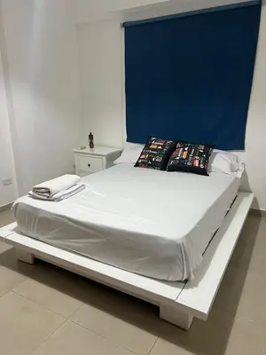 a large bed in a room with a blue wall at Apartamento a 5 minutos Zona Colonial in Santo Domingo