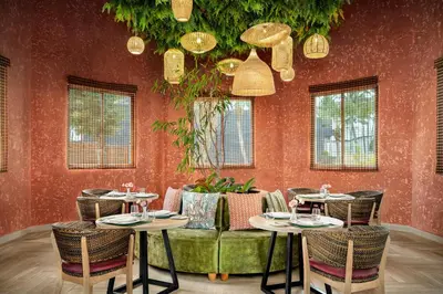 a restaurant with two tables and a green couch at Sunscape Dominicus La Romana - All Inclusive in Bayahibe