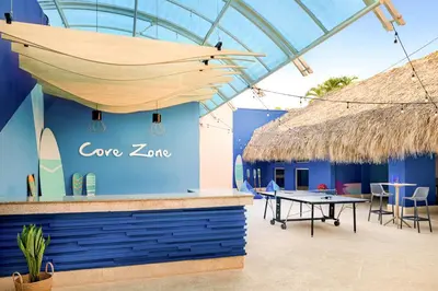 a restaurant with a table and a straw roof at Sunscape Dominicus La Romana - All Inclusive in Bayahibe