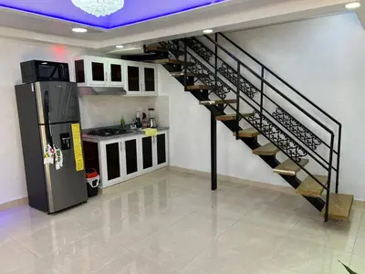 a spiral staircase in a kitchen with a refrigerator at Alojamiento paulino in Santiago de los Caballeros