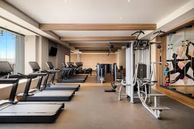 a gym with a row of treadmills and machines at Secrets Tides Punta Cana - All Inclusive in Punta Cana