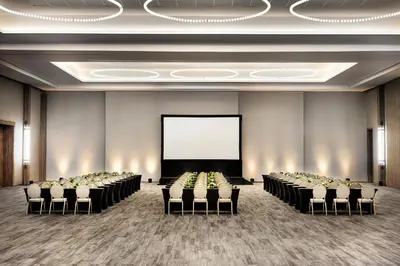 a conference room with rows of chairs and a screen at Secrets Tides Punta Cana - All Inclusive in Punta Cana