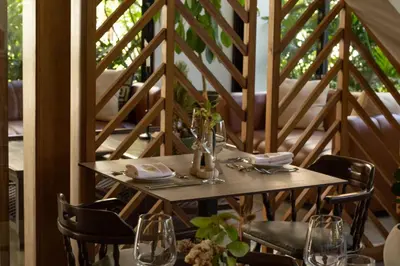 a wooden table with chairs and a table with glasses at Hotel Pinar Dorado By Hotel Gran Jimenoa in Jarabacoa