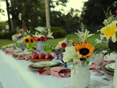 a table with plates and vases filled with flowers at Hotel Pinar Dorado By Hotel Gran Jimenoa in Jarabacoa