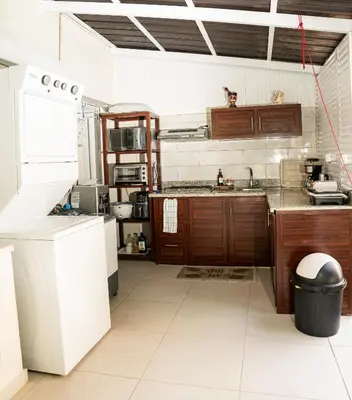 a kitchen with wooden cabinets and a sink at Habitación privada en Puerto Plata Bayardo in San Felipe de Puerto Plata