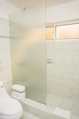 a bathroom with a toilet and a glass shower at Apartamento Los Anturios en Puerto Plata Bayardo in San Felipe de Puerto Plata
