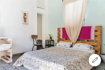 a bedroom with a large bed with a wooden headboard at Room in the Colonial Zone in Santo Domingo