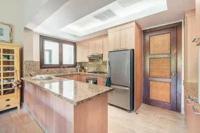 a kitchen with wooden cabinets and a stainless steel refrigerator at Nearby beach and beach club at Portillo NF in Las Terrenas