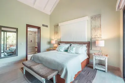 a bedroom with a bed and a chair and a window at Nearby beach and beach club at Portillo NF in Las Terrenas