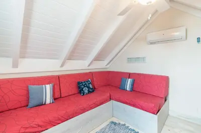 a red couch with pillows on it in a room at Nearby beach and beach club at Portillo NF in Las Terrenas