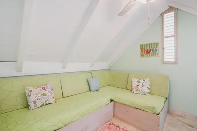 a green couch in a room with a window at Nearby beach and beach club at Portillo NF in Las Terrenas