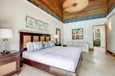 a bedroom with a large bed with a wooden ceiling at Luxurious 8-BR Villa with Ocean View, Jacuzzi, Home Cinema and Resort Access in Casa de Campo in La Romana