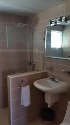 a bathroom with a sink and a shower and a mirror at Hotel Voramar in Sosúa