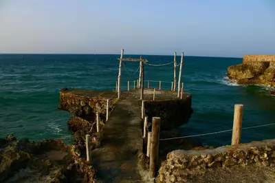 a wooden bridge over the ocean near the ocean at Villas El Bucanero in San Felipe de Puerto Plata