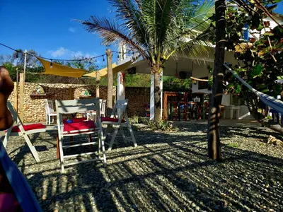 a yard with chairs and a palm tree and a house at Villas El Bucanero in San Felipe de Puerto Plata