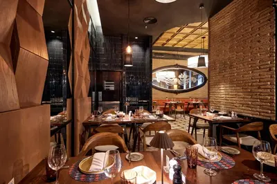 a restaurant with tables and chairs and a brick wall at Riu Palace Macao - Adults Only - All Inclusive in Punta Cana