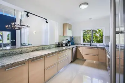 a kitchen with wooden cabinets and a large counter top at Stunning 3-Bedroom Villa with Pool, Jacuzzi and Maid near Bavaro Beach in Punta Cana